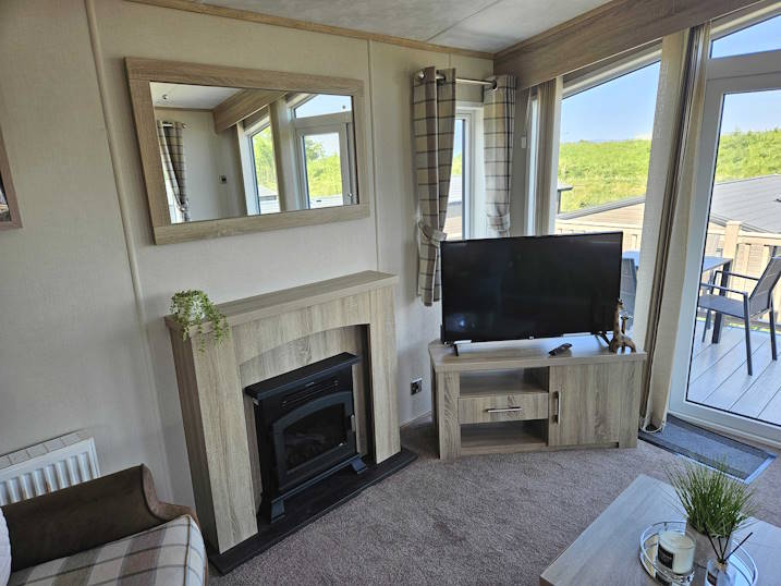 Living room including flat screen TV with Freeview.