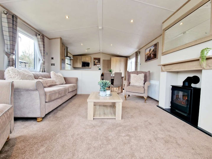 Inside of the lodge showing the fireplace and living room, and the kitchen and dining area further back.